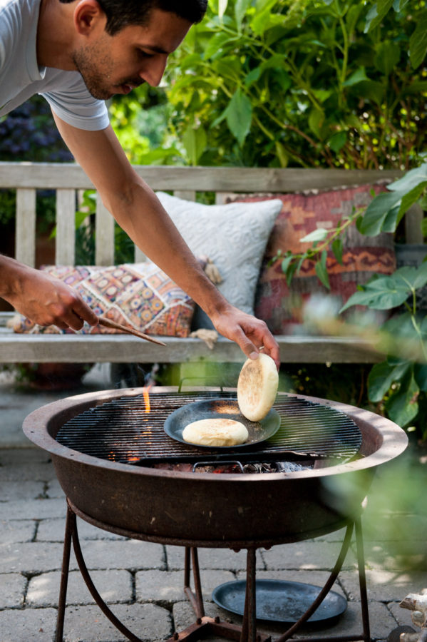 chef putting bread dough on the grill